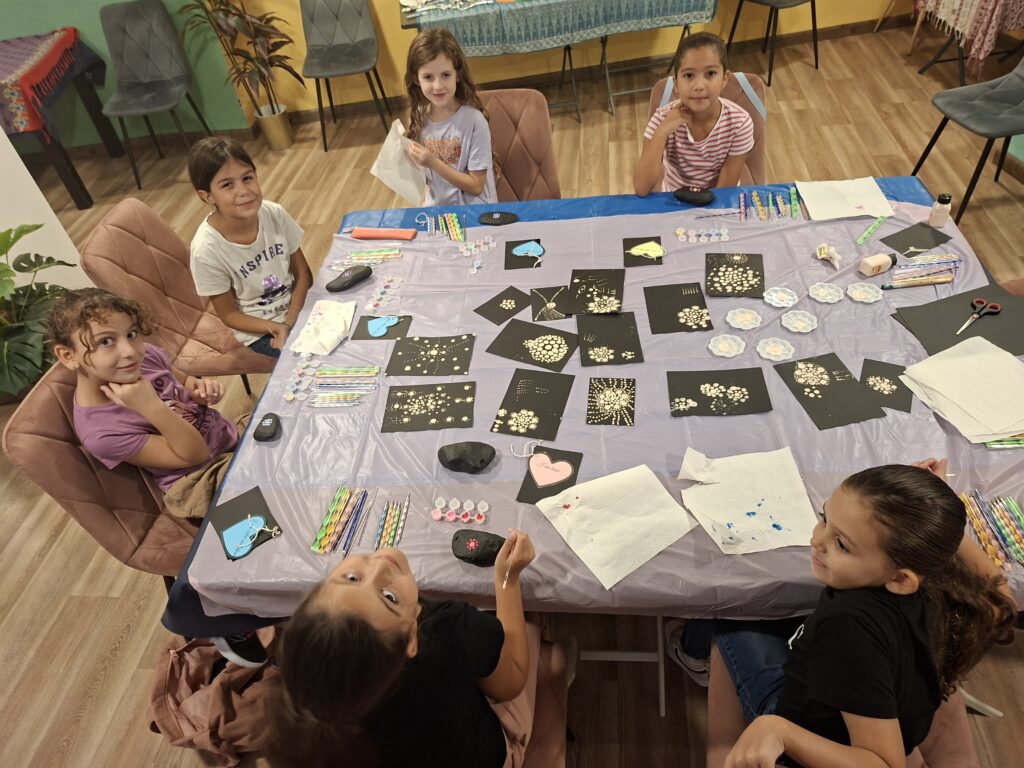 Mandala Vibes Kids Workshop table filled with stones, paints, and artworks created by young artists in Malta.
